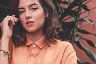 Brunette haired girl in peach colored t-shirt with charming eyes